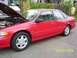 1995 Ford Taurus - Red 1995 Ford Taurus sedan with hood open, parked on a residential street.