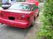 1995 Ford Taurus - A red 1995 Ford Taurus sedan is parked on the side of the road with its trunk open.