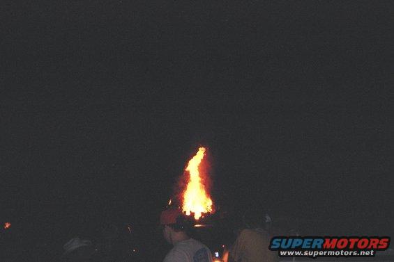 Bonfire erupting from the roof of a dark vehicle at night