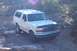 1995 Ford Bronco - White 1995 Ford Bronco navigating an off-road path with rocky terrain.