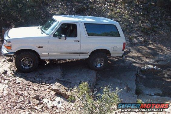 1995 Ford Bronco driving over rocks on a trail