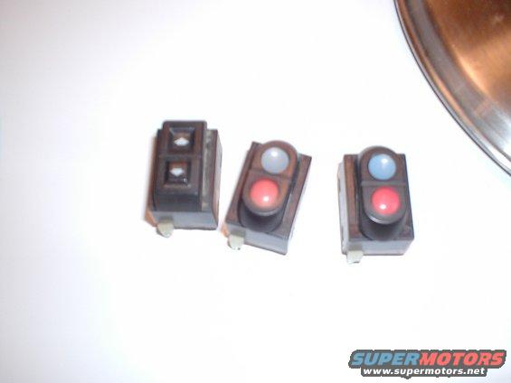 Three automotive interior switches: one with two diamond-shaped buttons, two with red and blue indicator lights