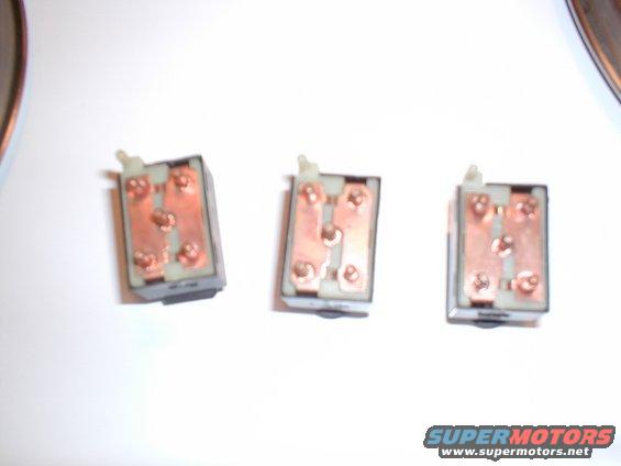 Three automotive electrical switches with copper terminals are shown against a white background