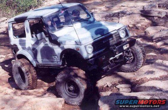 Suzuki Samurai with camouflage paint on rocky terrain