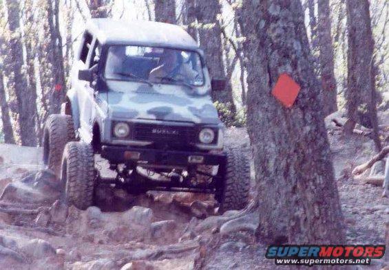 Suzuki Samurai with camouflage paint on rocky terrain