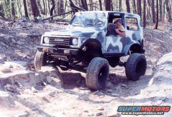 Camouflaged Suzuki Samurai navigating rocky terrain