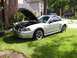 2002 Ford Mustang - Silver 2002 Ford Mustang convertible parked on lawn, hood up, showing engine bay.