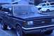 1989 Ford Bronco - A dark blue Ford Bronco is parked in front of a house with other vehicles behind it.