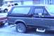 1989 Ford Bronco - This two-tone Ford Bronco, likely from the late 1980s, is seen parked outdoors with other vehicles nearby.