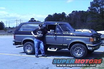 Guy standing next to a 1989 Ford Bronco