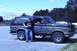 1989 Ford Bronco - A man poses with his two-tone Ford Bronco parked in a lot.