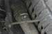 1989 Ford Bronco - Detail of a vehicle's suspension system, including a shock absorber and tire tread.