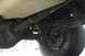 1989 Ford Bronco - A close-up view of the undercarriage of a vehicle, revealing mechanical parts and a tire.