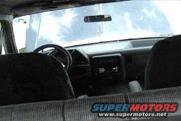 Inside of a truck cab, looking forward. Hood is up