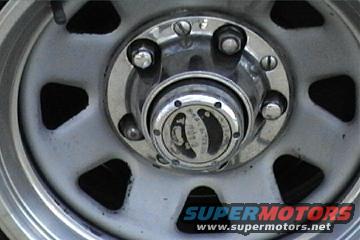 Close-up of a vehicle's front wheel hubcap with a SuperMotors logo visible
