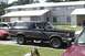 1989 Ford Bronco - A dark gray and black Ford Bronco is parked on a street in front of apartment buildings.