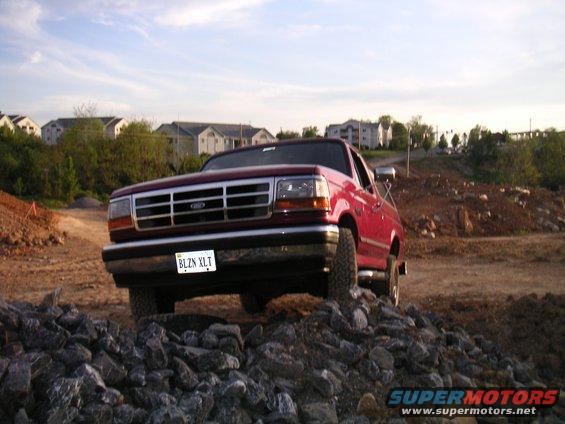 Red 1994 Ford Bronco 3q-front view on rocky terrain
