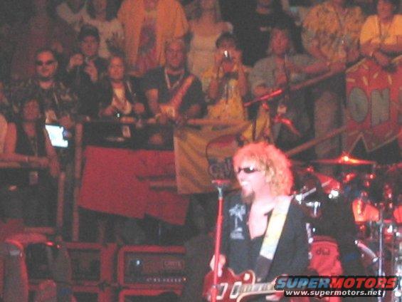 Crowd watching a musician with curly blonde hair play guitar on stage