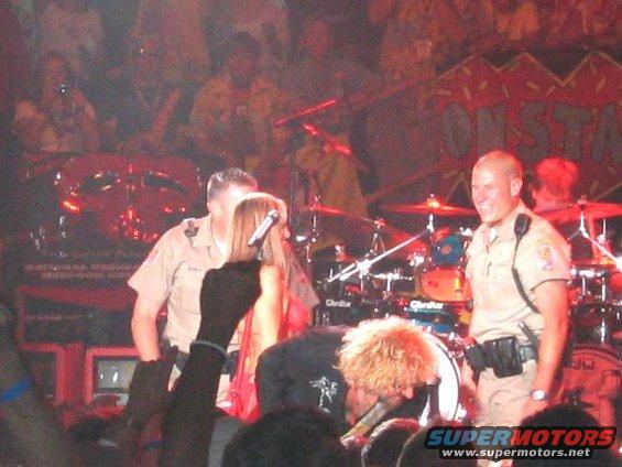 Stage performance with band and security personnel