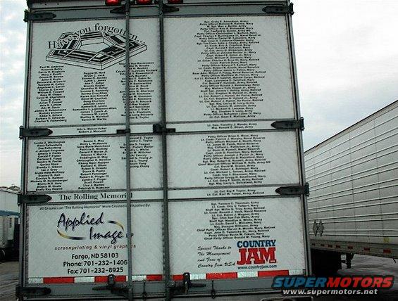 Rear of a trailer with lists of names, Pentagon graphic, and logos for Applied Image and Country Jam. Another trailer is visible to the right