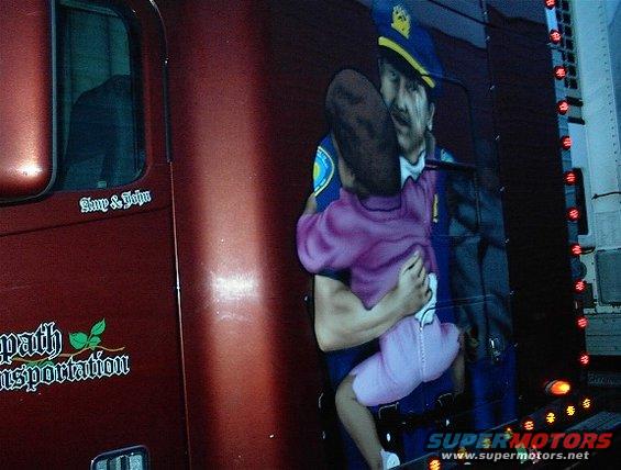 Maroon truck side with mural of a police officer holding a child, and text 'Symp & John' and 'path Transportation'