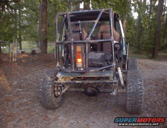 1989 Ford Bronco modified with a roll cage and off-road tires, rear view