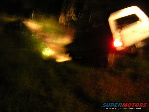 White SUV rear view at night with taillight illuminated