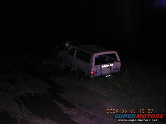 SUV with 'Baja Club' sticker on the back, parked off-road at night