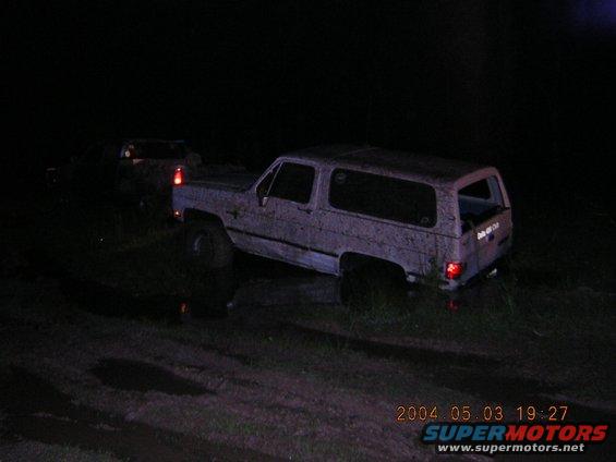 1984 Chevrolet Blazer, mud-covered, parked on uneven ground at night