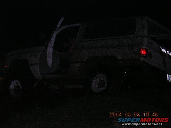 SUV with doors open, appears stuck in mud at night. Text on rear says 'Delta 4X4'