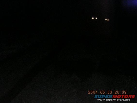 Two pairs of headlights visible in the dark