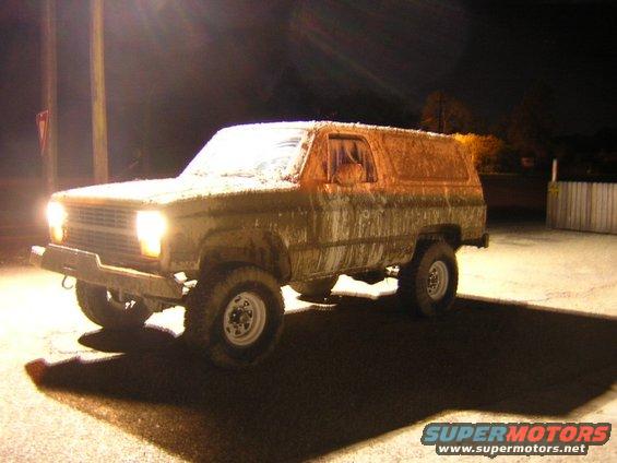 Mud-covered 1984 Chevrolet K5 Blazer parked at night under lights