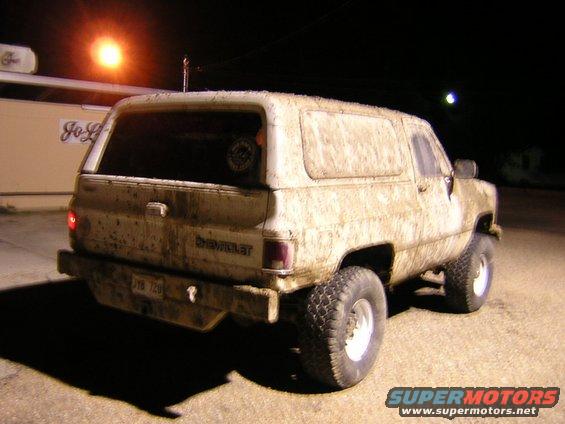 Mud-covered 1984 Chevrolet K5 Blazer, rear view, with a lifted suspension and off-road tires