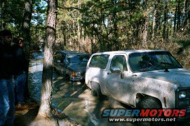 White SUV stuck in mud with another vehicle behind it