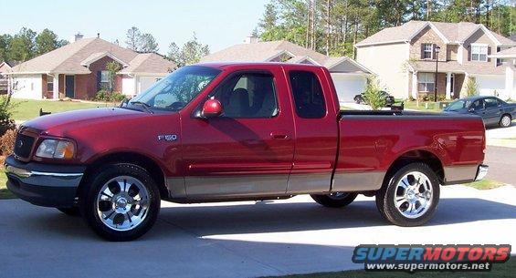 Red pickup truck with a tan lower body and chrome wheels, seen from the side