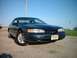 1996 Ford Thunderbird - A dark green 1996 Ford Thunderbird coupe is parked outdoors under a clear blue sky.