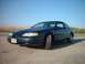 1996 Ford Thunderbird - 1996 Ford Thunderbird parked on a dirt road under a clear blue sky.