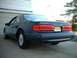 1996 Ford Thunderbird - Rear view of a dark blue 1996 Ford Thunderbird LX coupe parked in front of a garage.