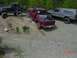 1992 Ford F-150 - Three trucks navigate a challenging off-road course on a sunny day.