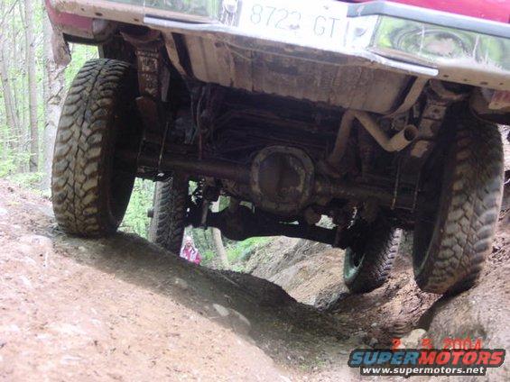 Underside of a truck on a dirt trail, showing suspension and tires