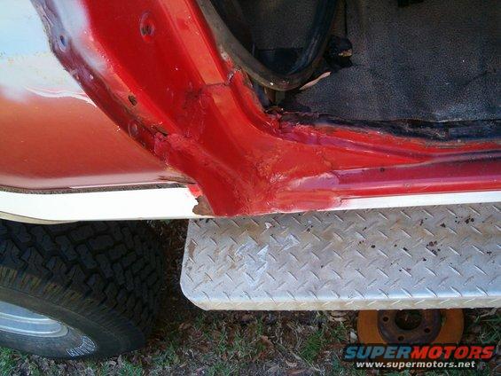 Rusted red door frame and diamond plate running board on a vehicle