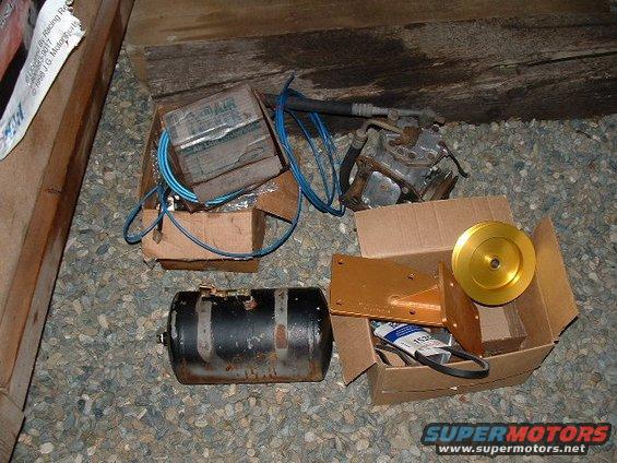 Cardboard boxes with automotive parts including an air compressor, tank, and pulley