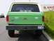 1990 Ford Bronco - Rear view of a green 1990 Ford Bronco with a white camper shell and various stickers on the tailgate.