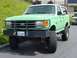 1990 Ford Bronco - This 1990 Ford Bronco features a prominent brush guard and an elevated suspension system, giving it a stance.