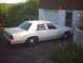 1991 Ford Crown Victoria - This 1991 Ford Crown Victoria sedan is seen parked next to a garage with overgrown plants in the foreground.