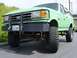 1990 Ford Bronco - A green 1990 Ford Bronco is shown from the front with a bull bar and off-road tires.