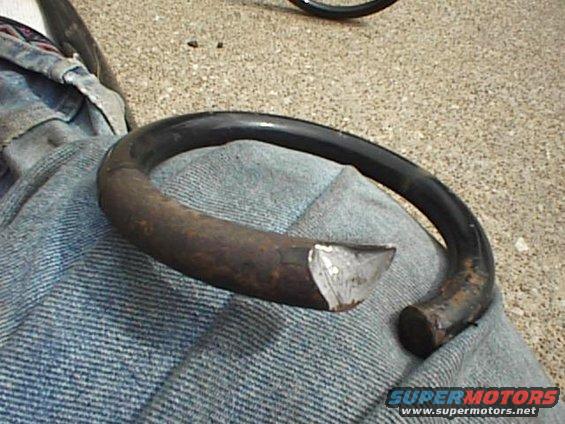 Cut metal spring resting on fabric, with a tire visible in the background