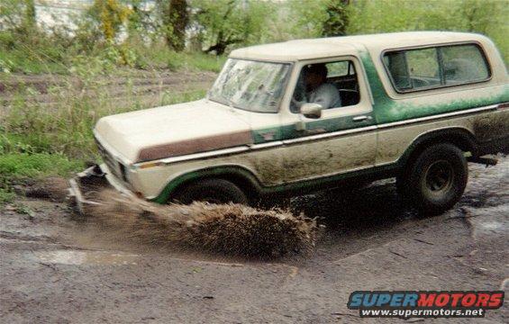 1978 Ford Bronco driving through mud, splashing water