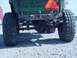 1992 Ford Bronco - This photo shows the rear axle and large off-road tires of a green vehicle, with contact information visible on the tailgate.