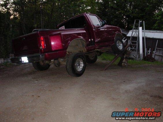 Red 1992 Ford F-150 on ramps, side view